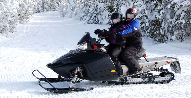 Coppia in sella ad una motoslitta a Livigno